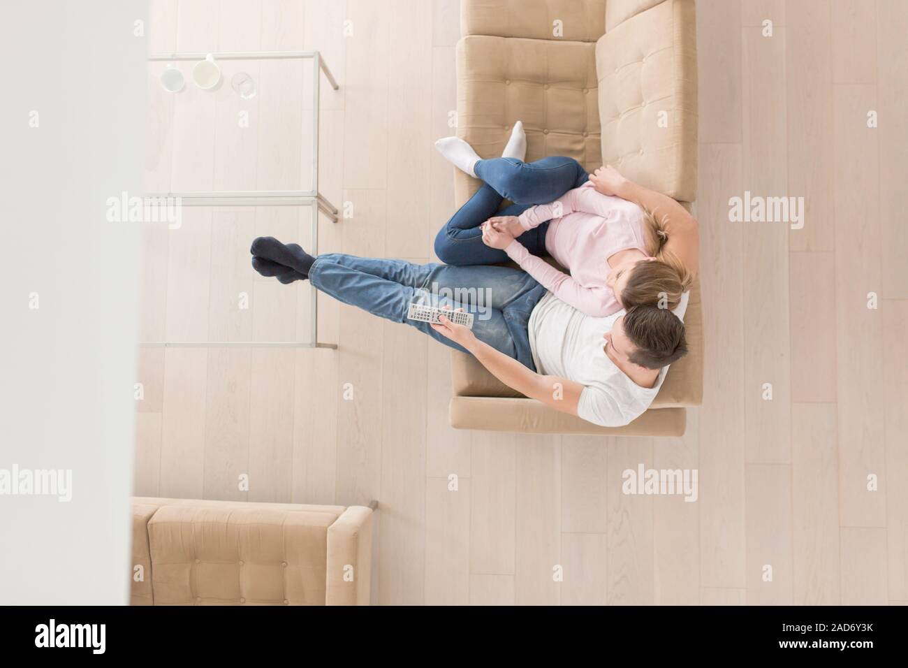 Jeune couple sur le canapé à regarder la télévision vue supérieure Banque D'Images