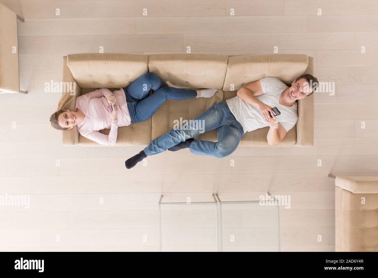 Jeune couple sur le canapé à regarder la télévision vue supérieure Banque D'Images