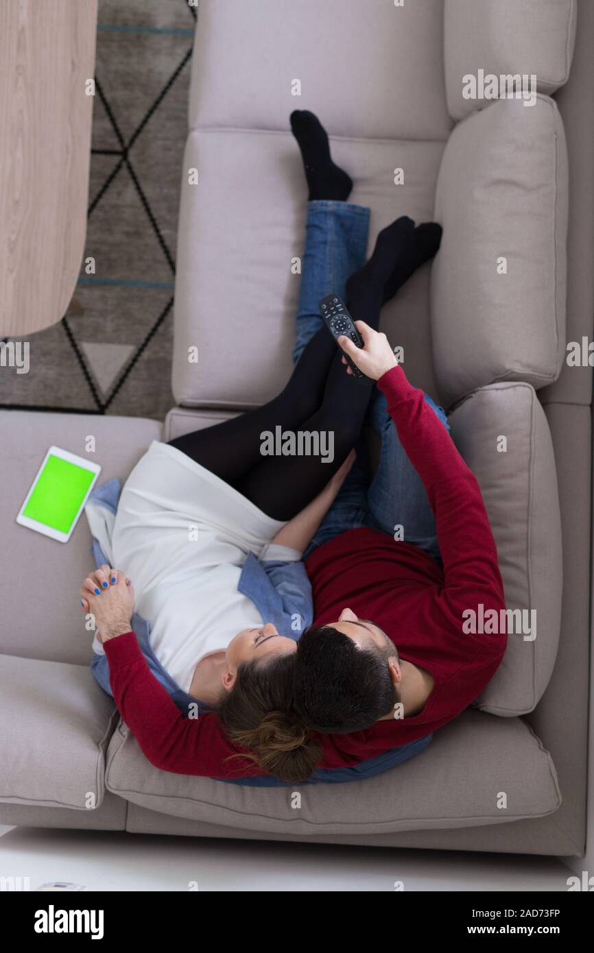 Jeune couple sur le canapé à regarder la télévision vue supérieure Banque D'Images
