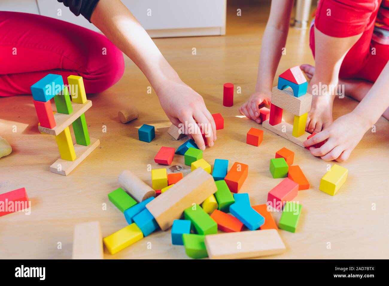 Les enfants qui jouent avec des blocs en bois coloré Banque D'Images