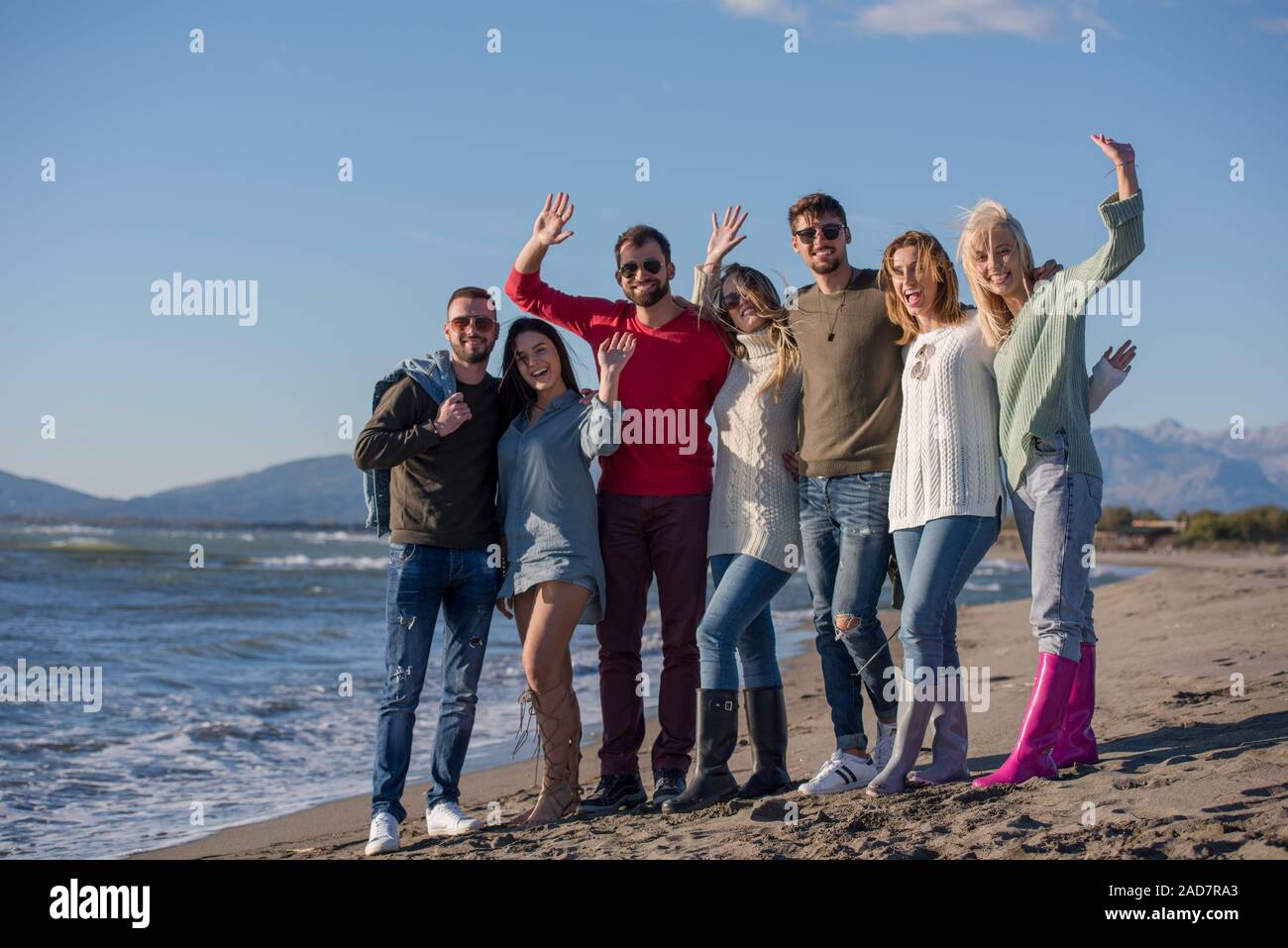 Portrait d'amis s'amusant sur la plage au cours de journée d'automne Banque D'Images