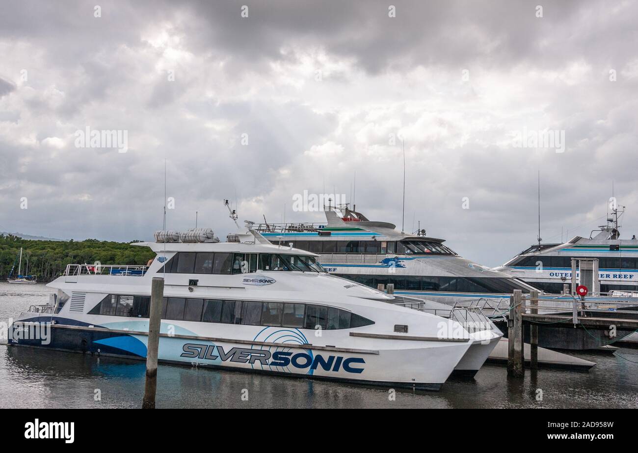 Port Douglas, Queensland, Australie - décembre 4, 2009 : 3 grands et luxueux yachts à moteur amarré au port sous de lourdes avec ceinture gris cloudscape gren Banque D'Images