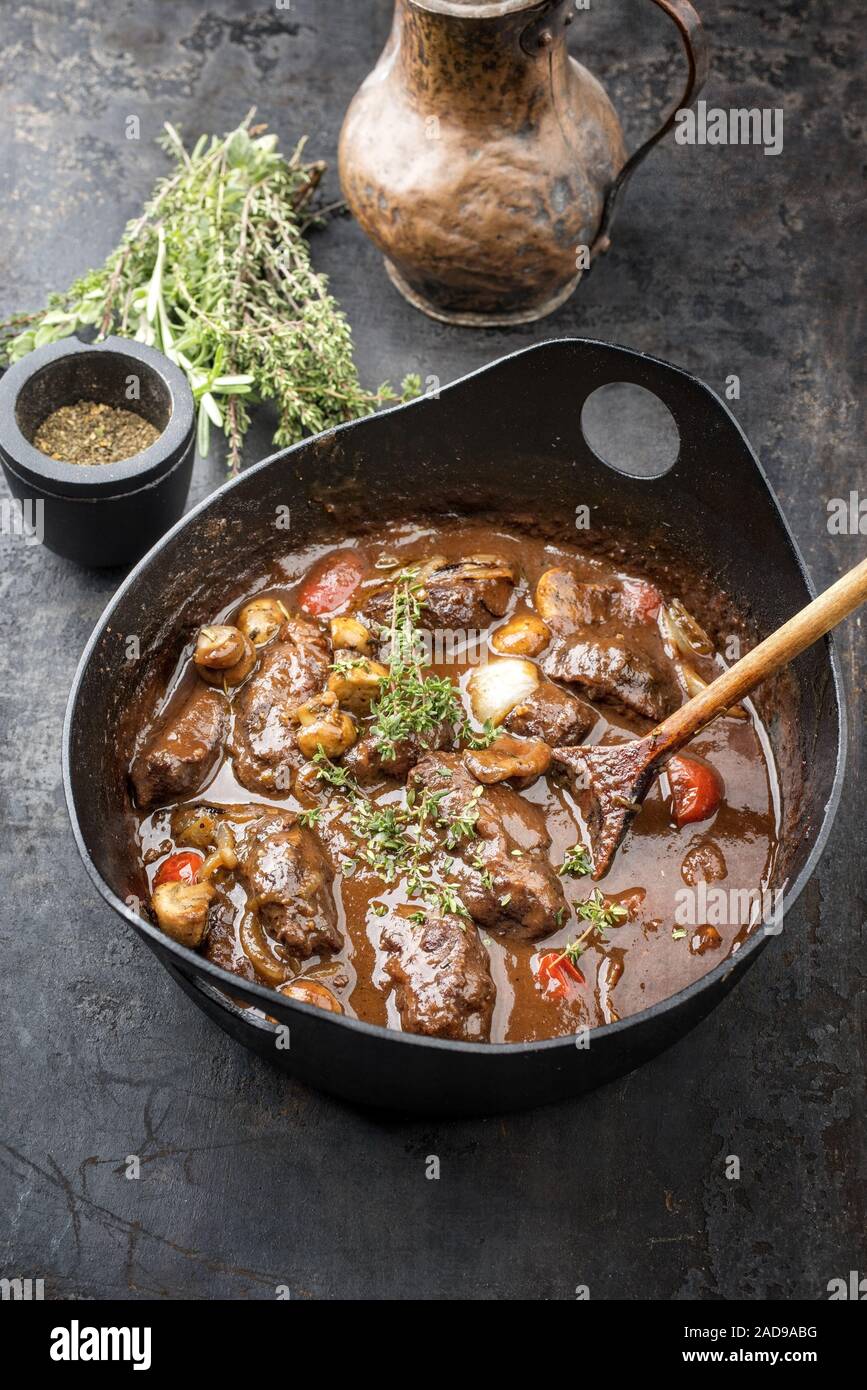 Joues de porc braisé traditionnel allemand en sauce brune avec champignons  et carottes comme libre dans un pot en fonte Photo Stock - Alamy
