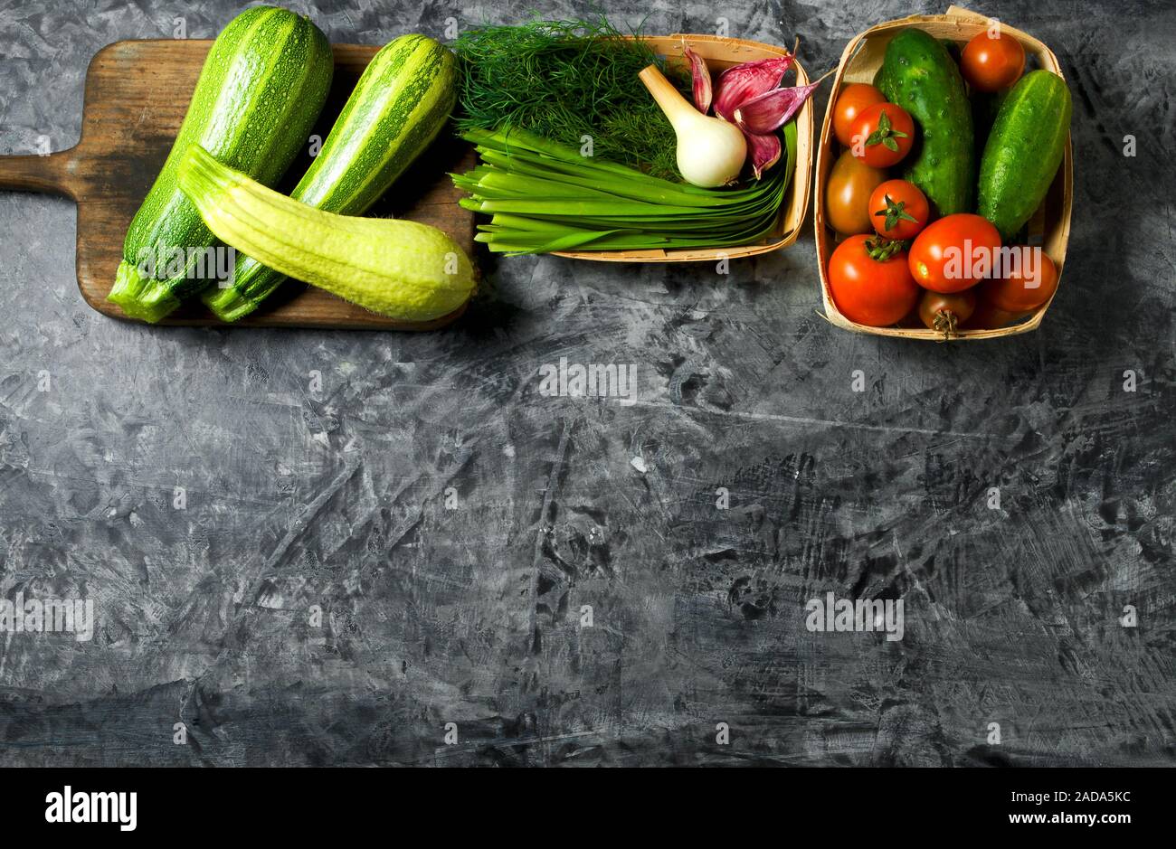 Des légumes sur l'arrière-plan. Légumes frais (concombres, tomates, oignons, ail, aneth, haricots verts) sur un fond gris. À Banque D'Images