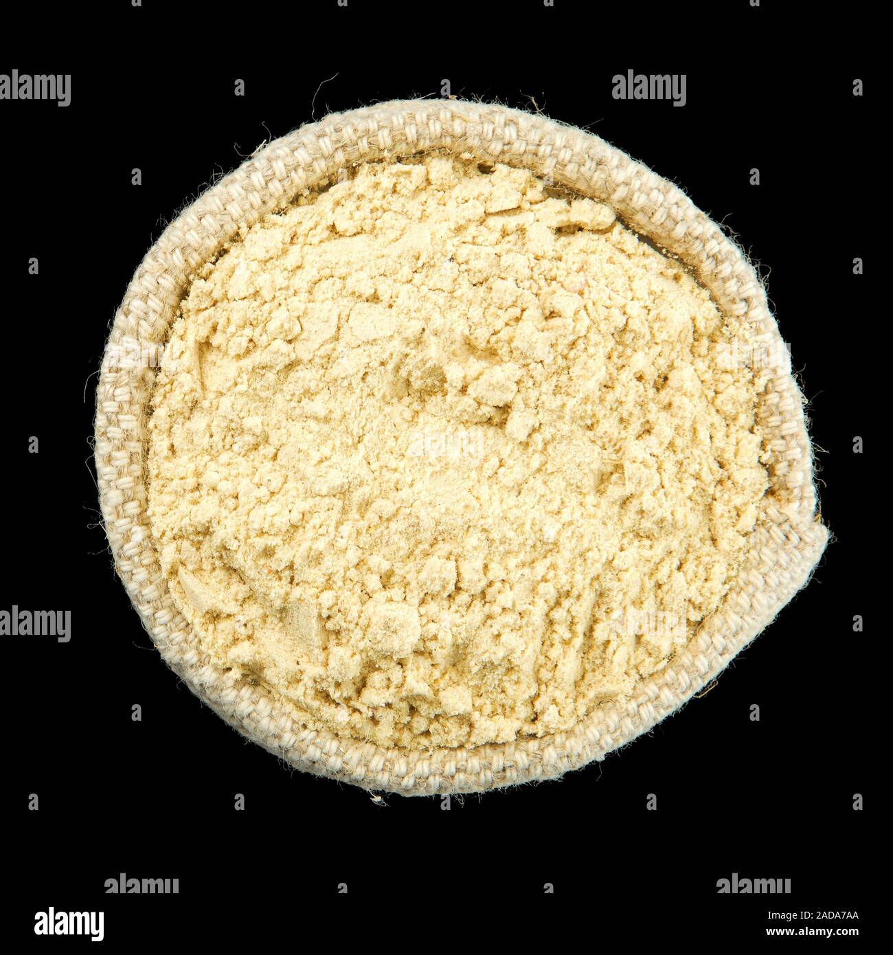 Gingembre en poudre dans un sac isolé sur fond noir. Vue de dessus. Isoler sur l'assaisonnement. Les épices sèches. Banque D'Images