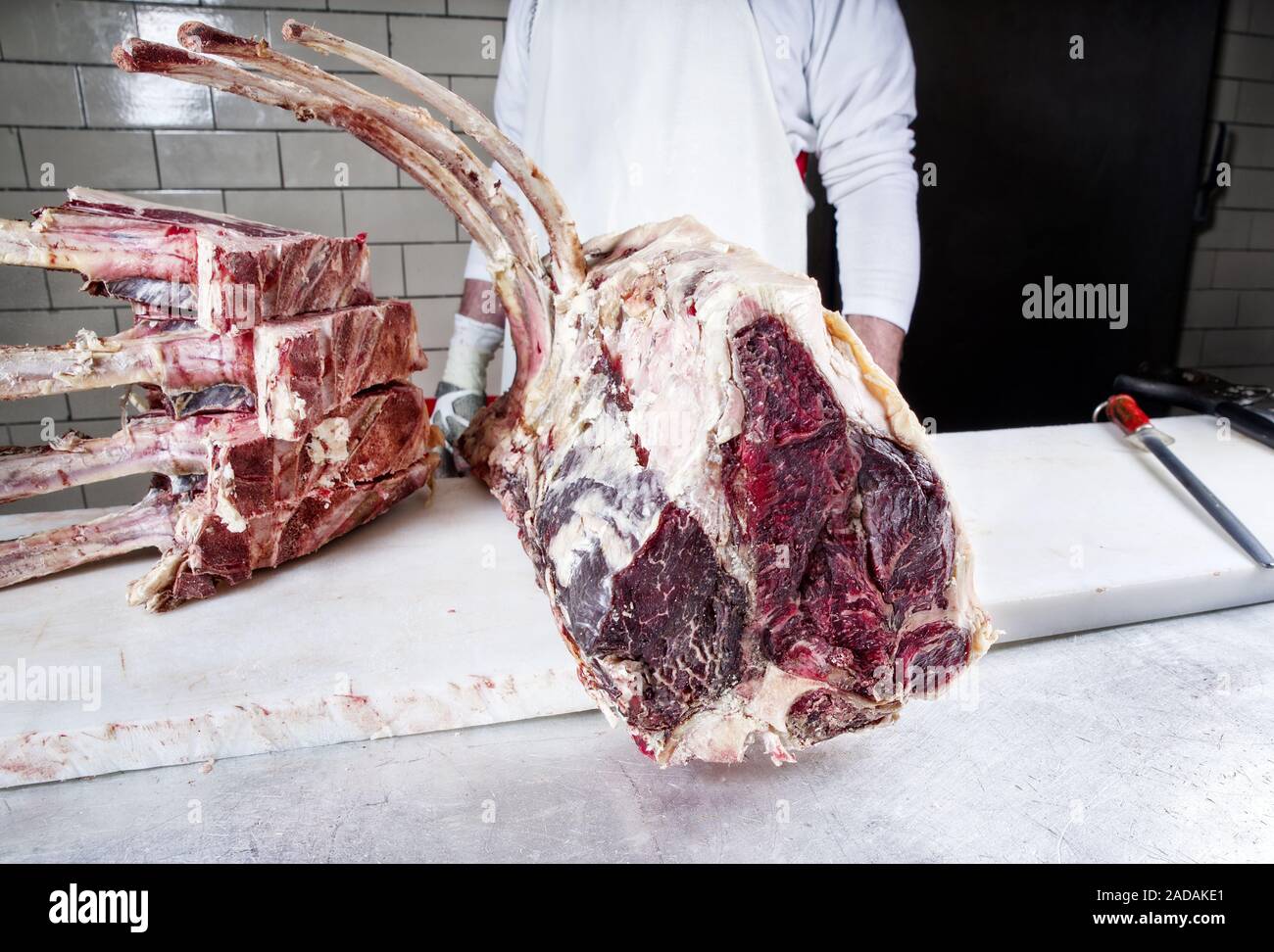 Sec brut de porterhouse steak wagyu tomahawk et couper en gros plan sur une table des bouchers Banque D'Images