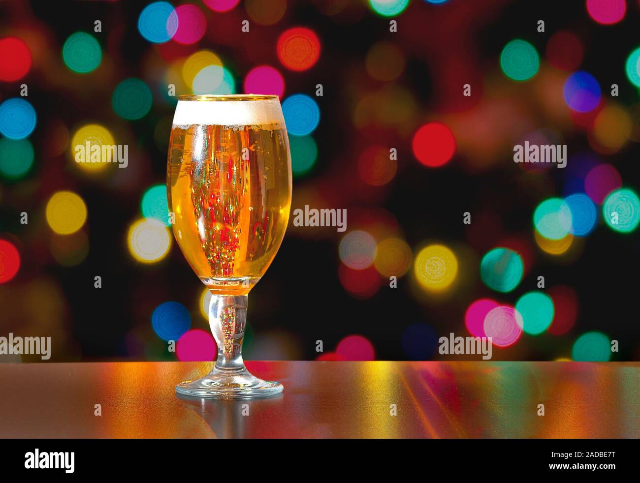 Une tasse de Stella Artois plein de bière avec maison de lumières colorées en arrière-plan Banque D'Images