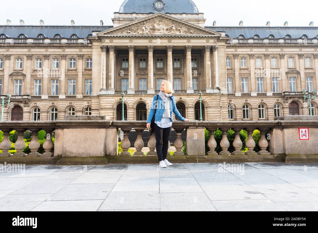 Jeune femme dans les tenues de stands touristiques sur fond de Palais Royal de Bruxelles et admire le monument, Belgique Banque D'Images