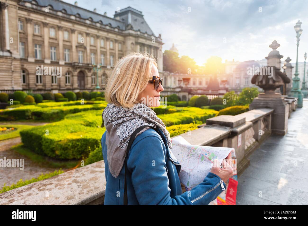 Jeune femme perdue dans la ville et lit une carte sur l'arrière-plan du Palais Royal à Bruxelles, Belgique Banque D'Images
