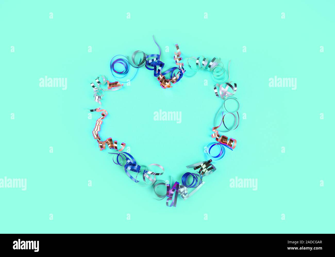 Forme de coeur fait de serpentine multicolores sur un fond de menthe. Contenu de l'art de fête. Place pour une inscription. Banque D'Images