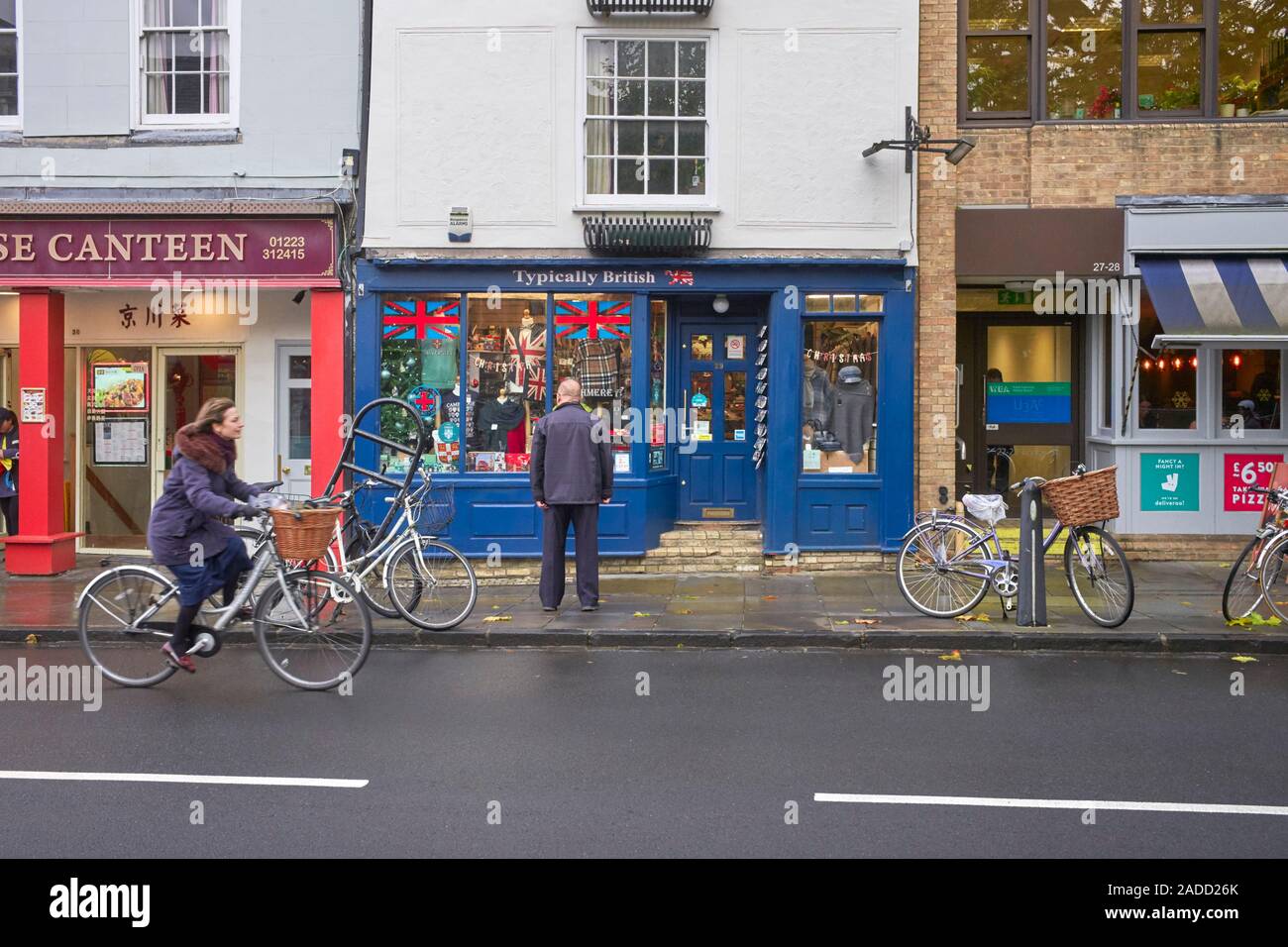 Un vieux à la recherche de touristes chinois à la fenêtre de la boutique typiquement à Cambridge Banque D'Images