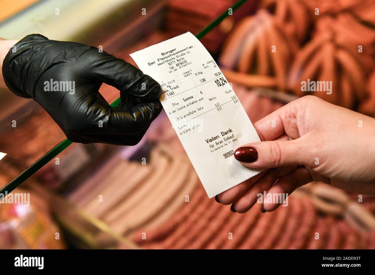 03 décembre 2019, Berlin : Une boucherie sous la réception donne à un client. Photo : Jens Kalaene Zentralbild-/dpa/ZB - ATTENTION : Seulement pour un usage éditorial dans le cadre de l'établissement de rapports sur l'artisanat ou de la boucherie et du commerce qu'avec mention complète de la crédit ci-dessus Banque D'Images