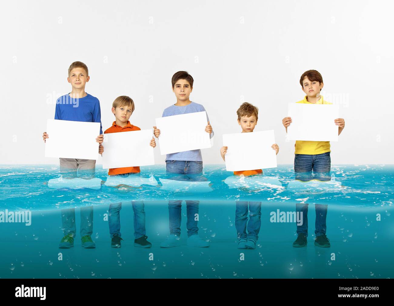 Noyé à la maison. Groupe d'enfants avec des bannières vierge debout dans l'eau de la fonte des glaciers, le réchauffement climatique. L'écologie, de l'environnement concept. Sauver la planète pour les générations futures, arrêter de dénaturer la nature. Banque D'Images