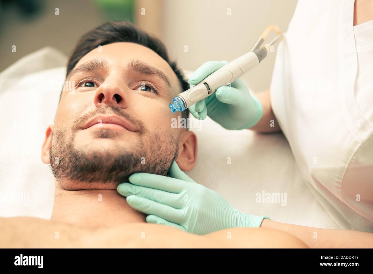 Visage de l'homme au cours de la procédure avec l'outil moderne de la peau Banque D'Images