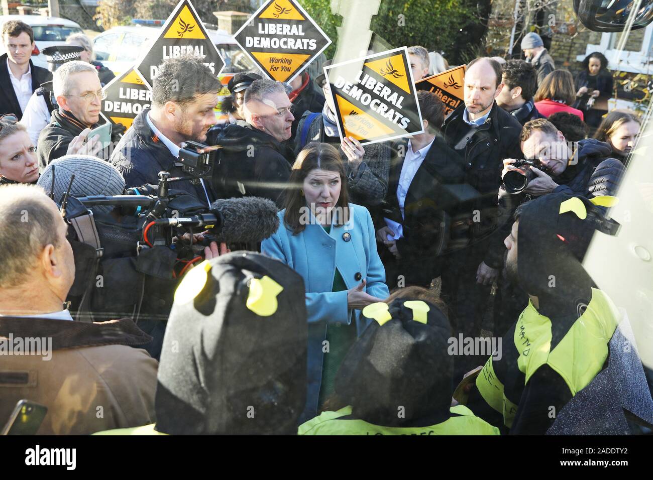 Le leader libéral démocrate Jo Swinson parle à l'extinction des manifestants déguisés en abeilles rébellion après qu'ils se sont collés à la partie bus bataille au cours d'une visite à l'établissement Knights Youth Centre à Londres, tandis que sur la campagne électorale générale trail. Banque D'Images