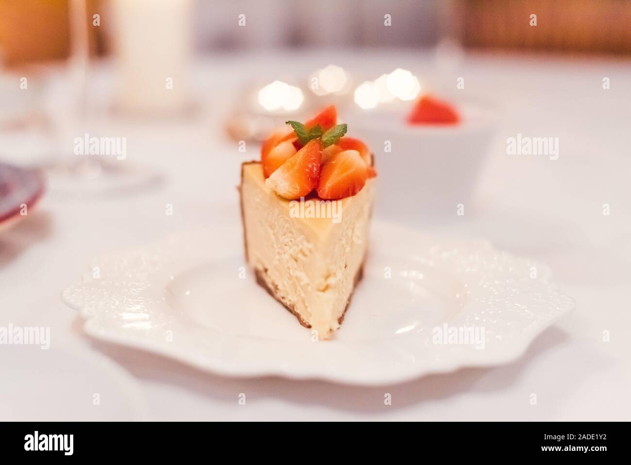Gâteau au fromage aux fraises fraîches sur une plaque en céramique sur un tableau blanc Banque D'Images