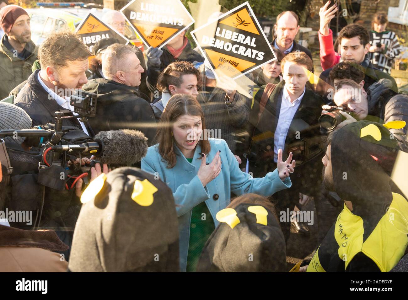 Le leader libéral démocrate Jo Swinson parle à l'extinction des manifestants déguisés en abeilles rébellion après qu'ils se sont collés à la partie bus bataille au cours d'une visite à l'établissement Knights Youth Centre à Londres, tandis que sur la campagne électorale générale Sentier.. Banque D'Images