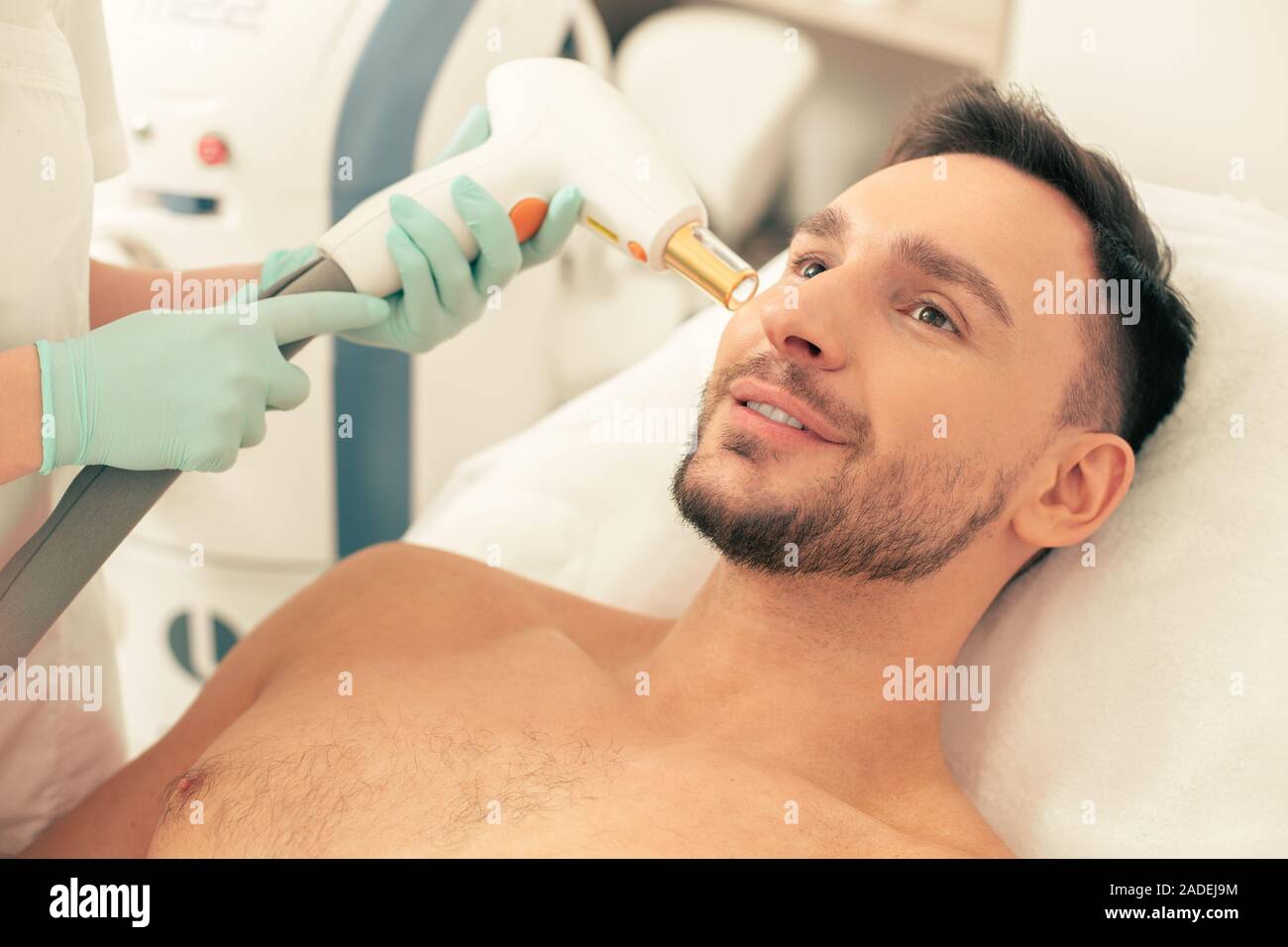 L'homme ayant un traitement au laser du visage à la clinique médicale Banque D'Images