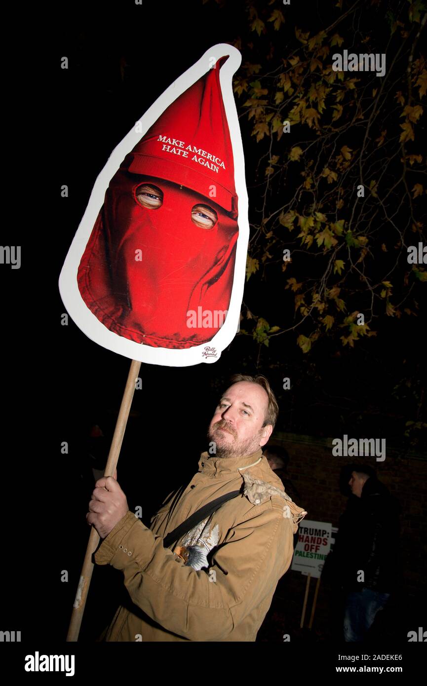 3 décembre 2019 Trafalgar Square. Manifestation anti Trump. Un homme tient une pancarte montrant Trump dans un style rouge Ku Kluk Klan masque et mots 'Make Ame Banque D'Images