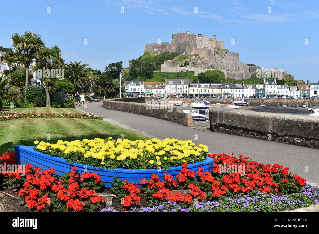 Château du Mont Orgueil Jersey qui surplombe le port de Gorey. Le jardin britannique fleurit en pleine floraison sur la promenade du bord de mer en été. Jersey, Royaume-Uni Banque D'Images