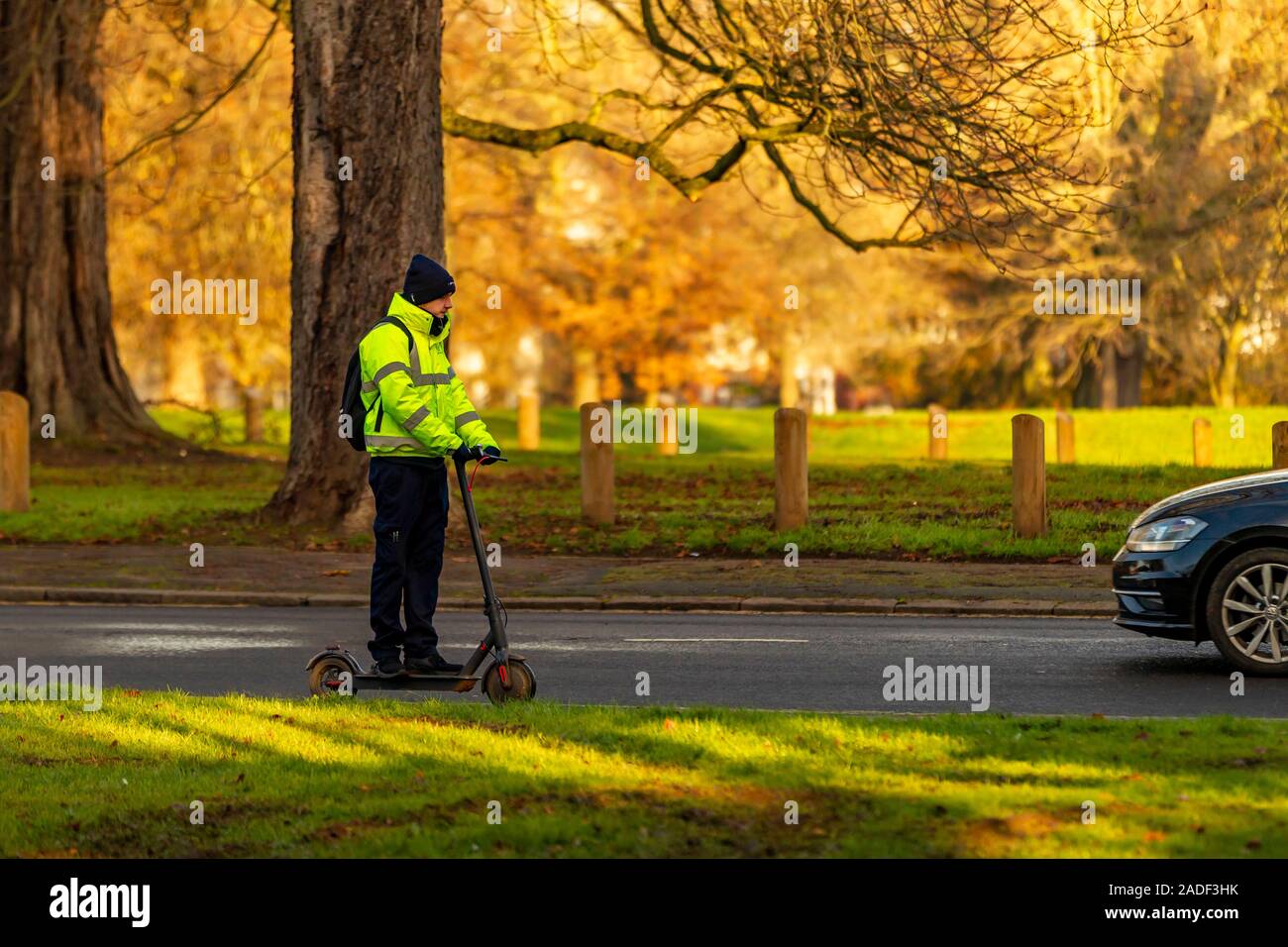 Un homme sur un scooter électrique-aider passe le long de Park Avenue South, Northampton, Royaume-Uni. Banque D'Images