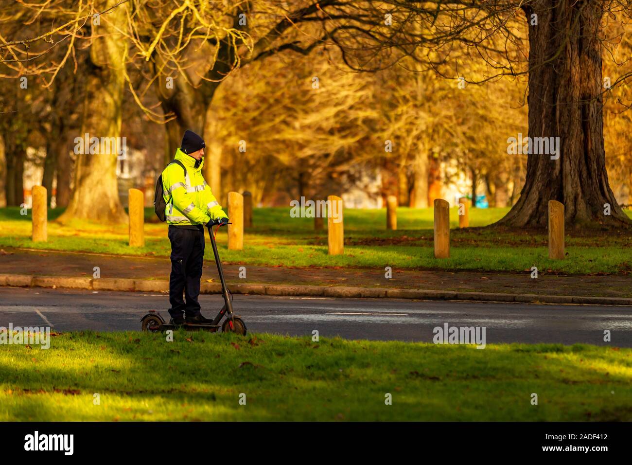 Un homme sur une bouilloire-aider scotter passe le long de Park Avenue South, Northampton, Royaume-Uni. Banque D'Images