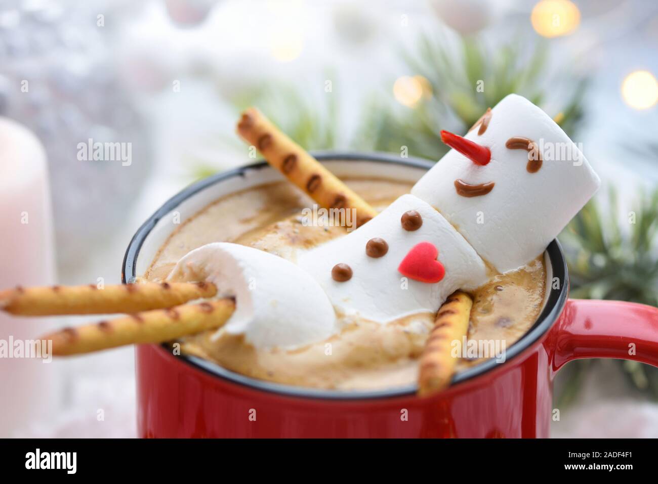 Mug rouge avec du cappuccino avec bonhomme guimauve fondue Banque D'Images