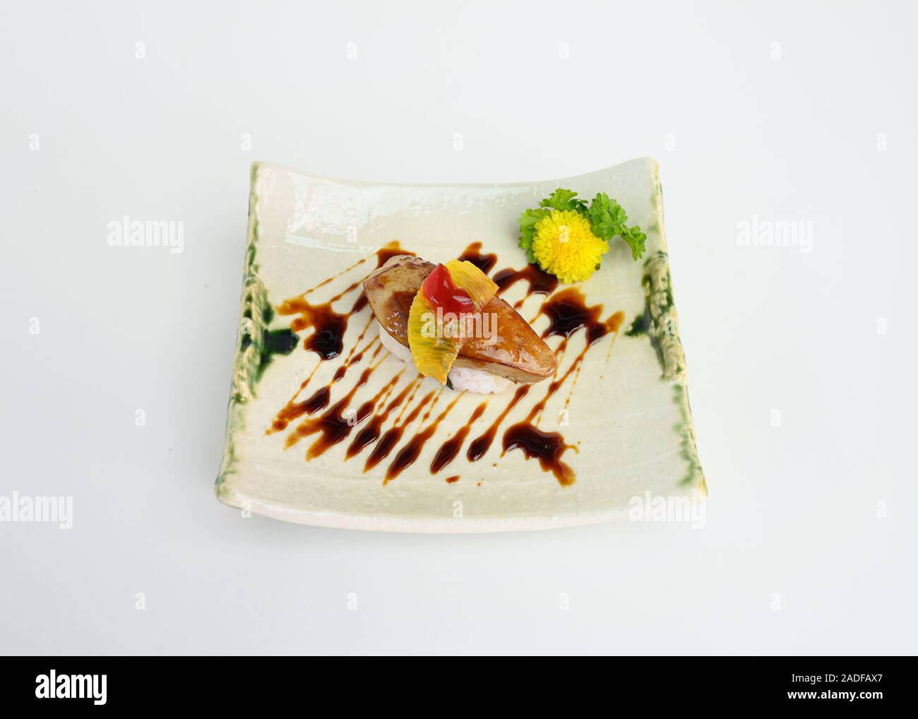 Foie Gras fumé avec sauce aux cerises et des sushis sur une plaque en céramique Banque D'Images