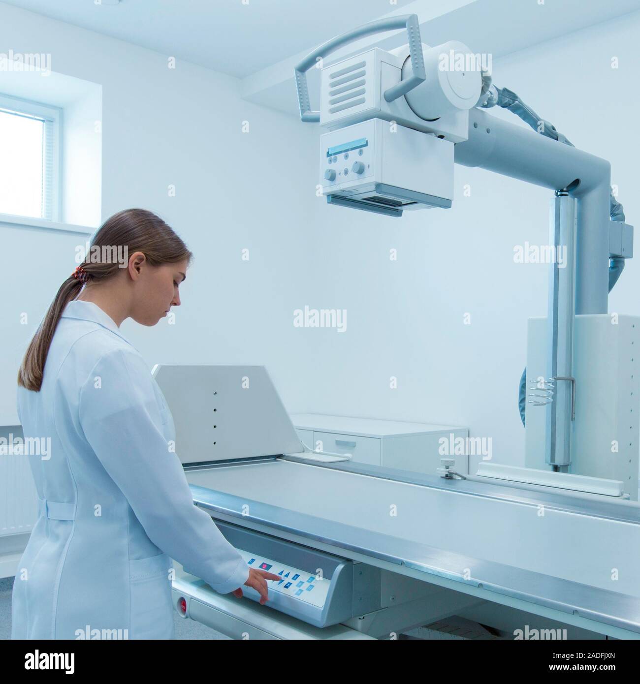 Femme préparant plus récent équipement à rayons X pour l'utilisation Banque D'Images