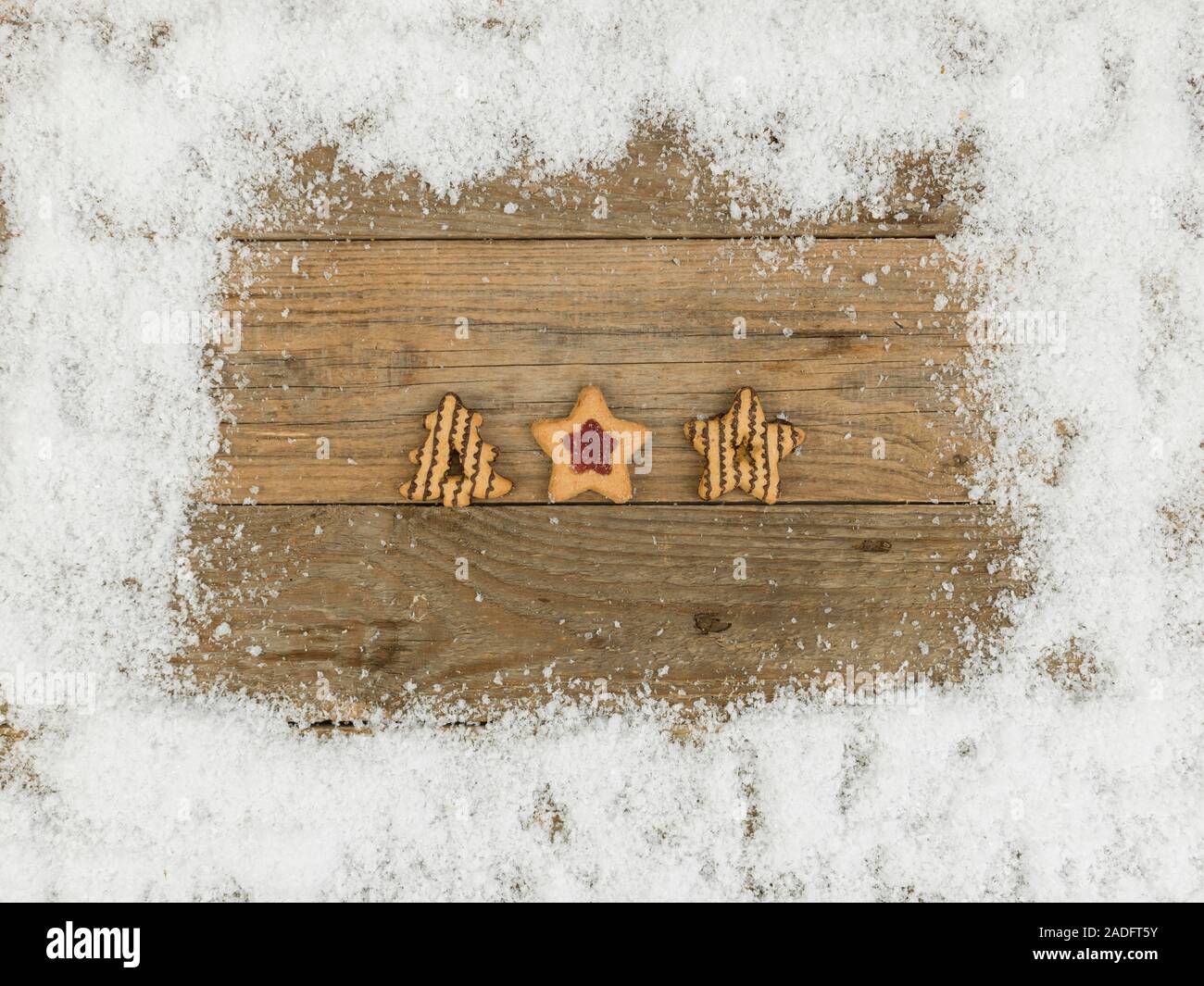 Beaucoup de différents biscuits de Noël sur fond de bois et de neige blanche Banque D'Images