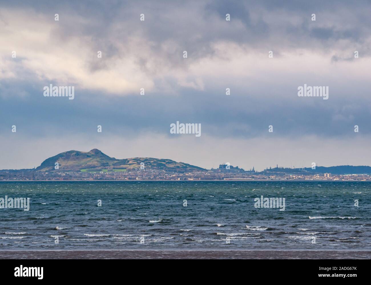 Longniddry Bents, East Lothian, Écosse, Royaume-Uni, 4 décembre 2019. Météo au Royaume-Uni : un ciel sombre et menaçant s'étend sur les gratte-ciel d'Édimbourg par une journée venteuse avec Arthur's Seat, le château d'Édimbourg, les monuments de Calton Hill et les hautes grues de travaux de rénovation visibles. Vue de Longniddry Bents sur le Firth FO Forth Banque D'Images