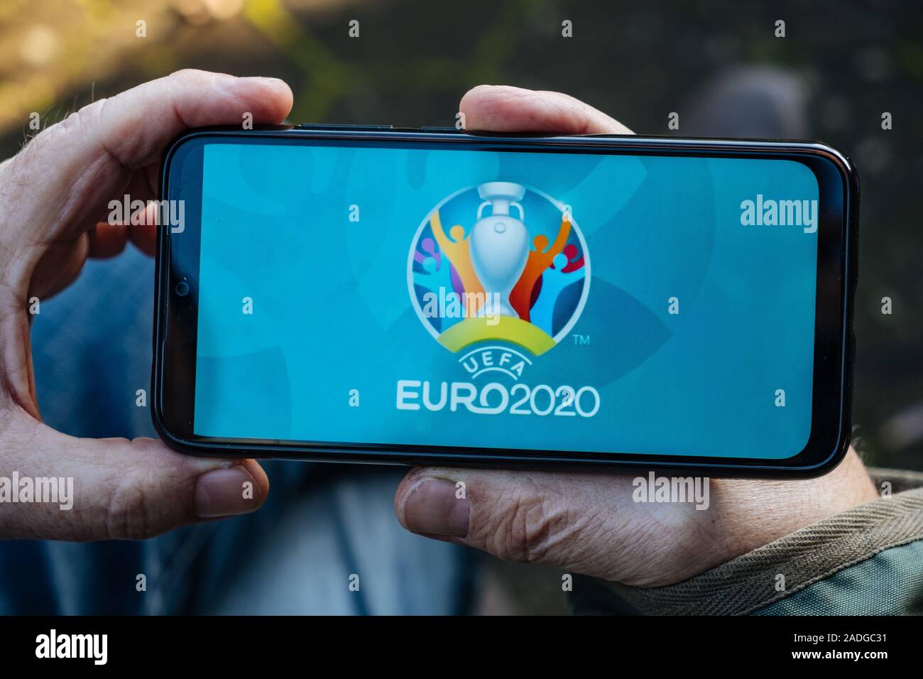 Senior Man holding est un smartphone avec le logo de l'UEFA Euro 2020 à l'écran Banque D'Images