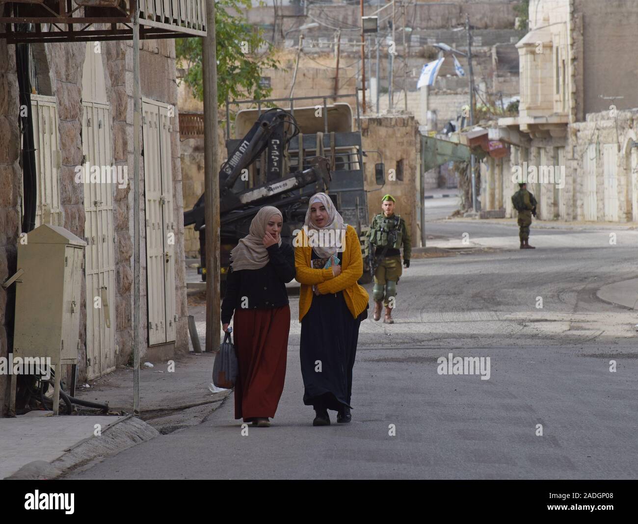 Un soldat israélien surveille les femmes palestiniennes à pied sur la rue Shuhada près du Tombeau des Patriarches, ou de la mosquée, dans la ville divisée de Hébron, en Cisjordanie, le Mercredi, Décembre 4, 2019. Le Ministre israélien de la Défense, Naftali Bennett a ordonné aux fonctionnaires de commencer à planifier une nouvelle colonie juive au coeur d'Hébron, dont les responsables palestiniens dire, c'est la suite de Le président américain Donald Trump a décidé de légitimer les colonies. Photo par Debbie Hill/UPI Banque D'Images