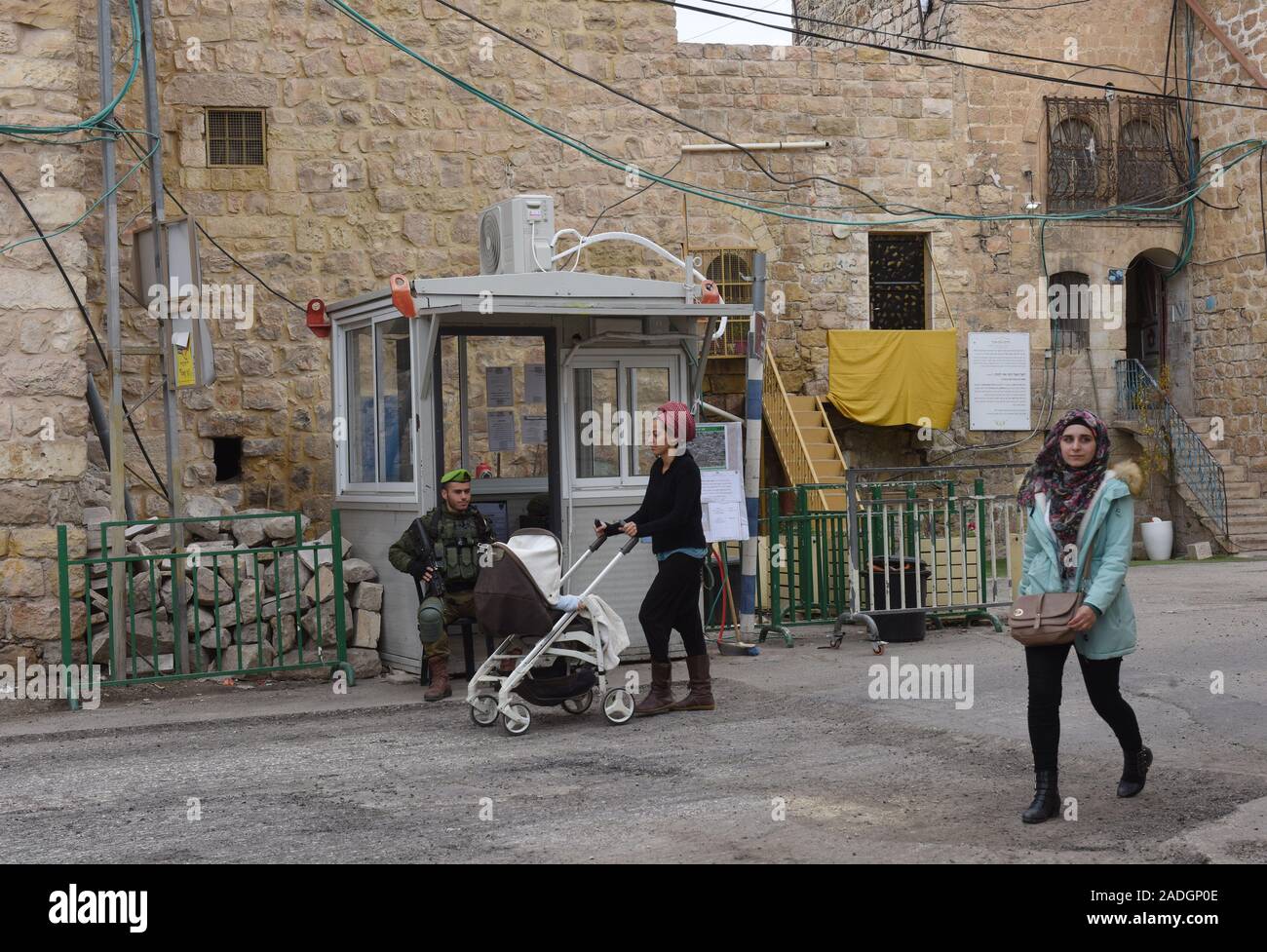 Un soldat israélien surveille une femme palestinienne et d'un colon juif pousser son bébé sur la rue Shuhada près du Tombeau des Patriarches, ou de la mosquée, dans la ville divisée de Hébron, en Cisjordanie, le Mercredi, Décembre 4, 2019. Le Ministre israélien de la Défense, Naftali Bennett a ordonné aux fonctionnaires de commencer à planifier une nouvelle colonie juive au coeur d'Hébron, dont les responsables palestiniens dire, c'est la suite de Le président américain Donald Trump a décidé de légitimer les colonies. Photo par Debbie Hill/UPI Banque D'Images