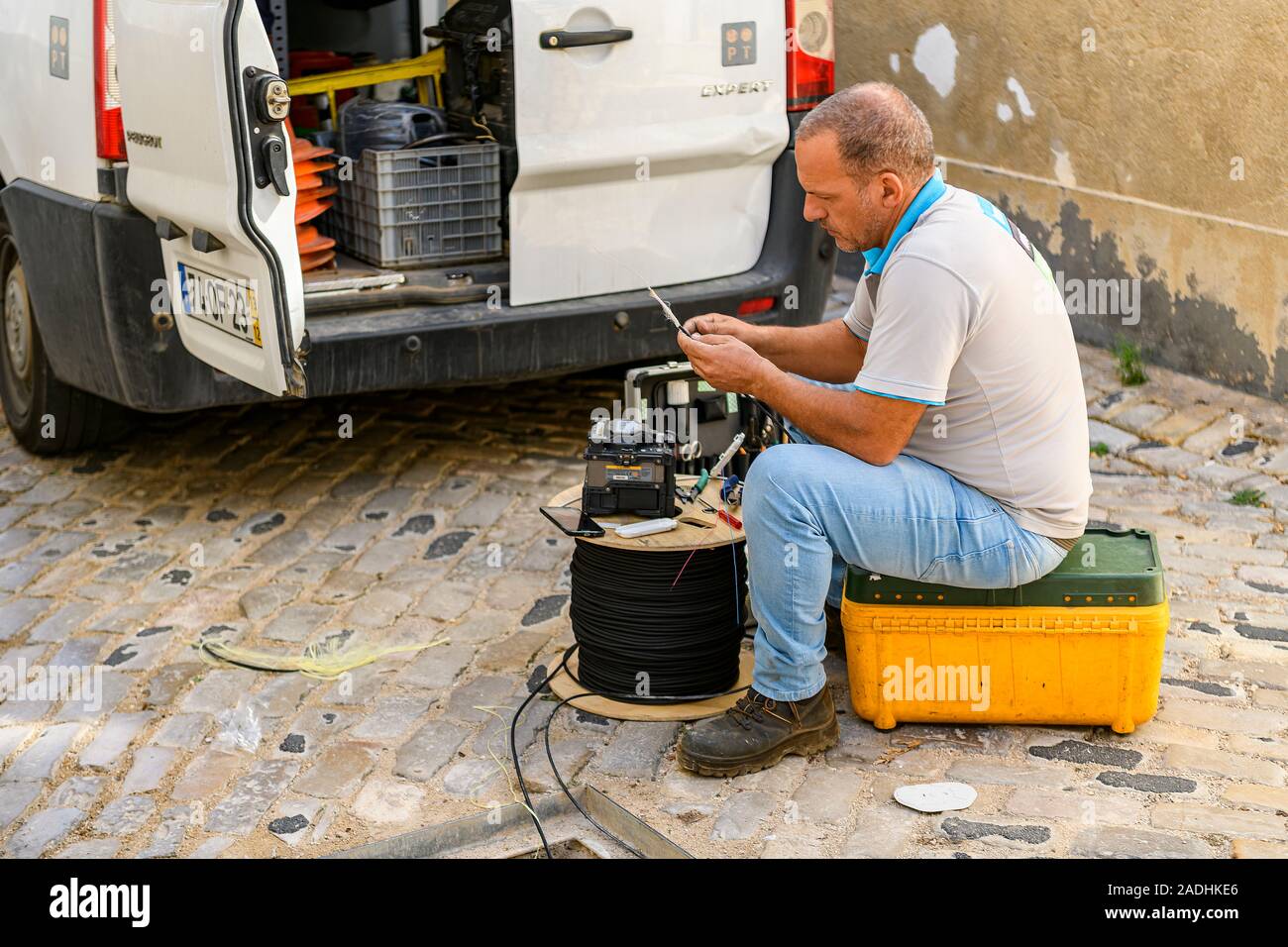 Technicien de téléphonie Faro qui fixe et pose des câbles à fibres optiques. Faro, Algarve de l'est, Portugal. Banque D'Images