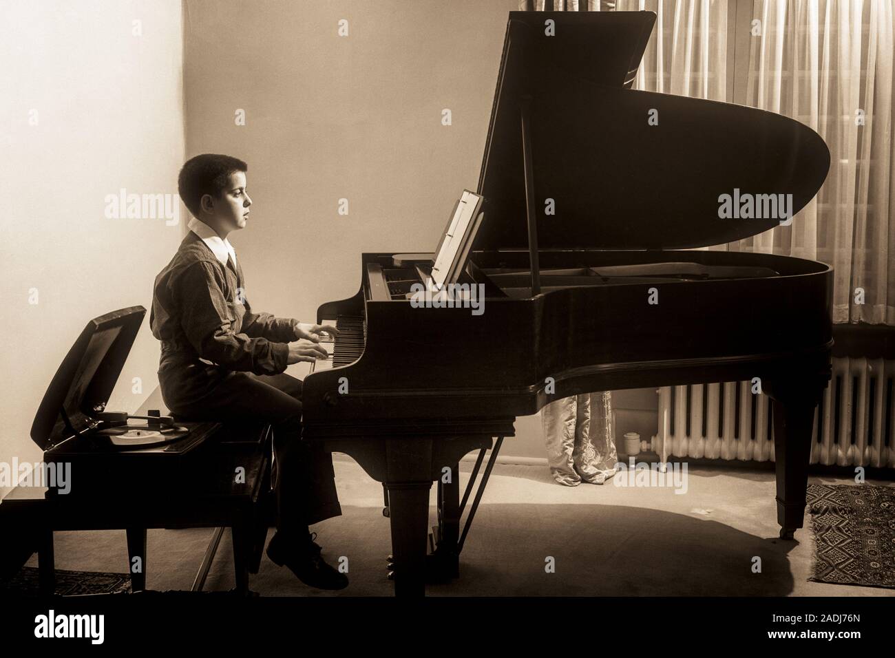 1950 BOY PRACTICING JOUER PIANO à l'ÉCOUTE DE RECORD PLAYER ASSIS À CÔTÉ DE LUI SUR LE BANC - m2106 HAR001 INSPIRATION HARS CONFIANCE DIVERTISSEMENT MÂLES B&W DE LA SCÈNE DES ARTS DE LA RÉUSSITE DES OBJECTIFS GRAND ANGLE RÊVES BONHEUR INTERPRÈTE STRATÉGIE FORCE PROGRÈS CHOIX FIERTÉ LOISIRS RECORD PLAYER SUR LES PROFESSIONS À LA CRÉATIVITÉ CONCEPTUELLE DE CONNEXION À CÔTÉ DE LA CROISSANCE DES JUVÉNILES LUI ÉLÉGANT PRÉ-ADO PRÉ-ADO GARÇON NOIR ET BLANC DE RELAXATION de précision de l'origine ethnique caucasienne HAR CONCENTRATION001 old fashioned pratiquer Banque D'Images