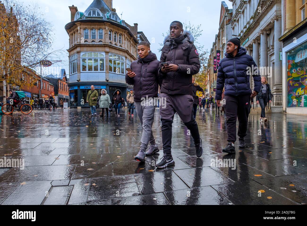 Les jeunes hommes à pied dans une rue piétonne animée. Banque D'Images