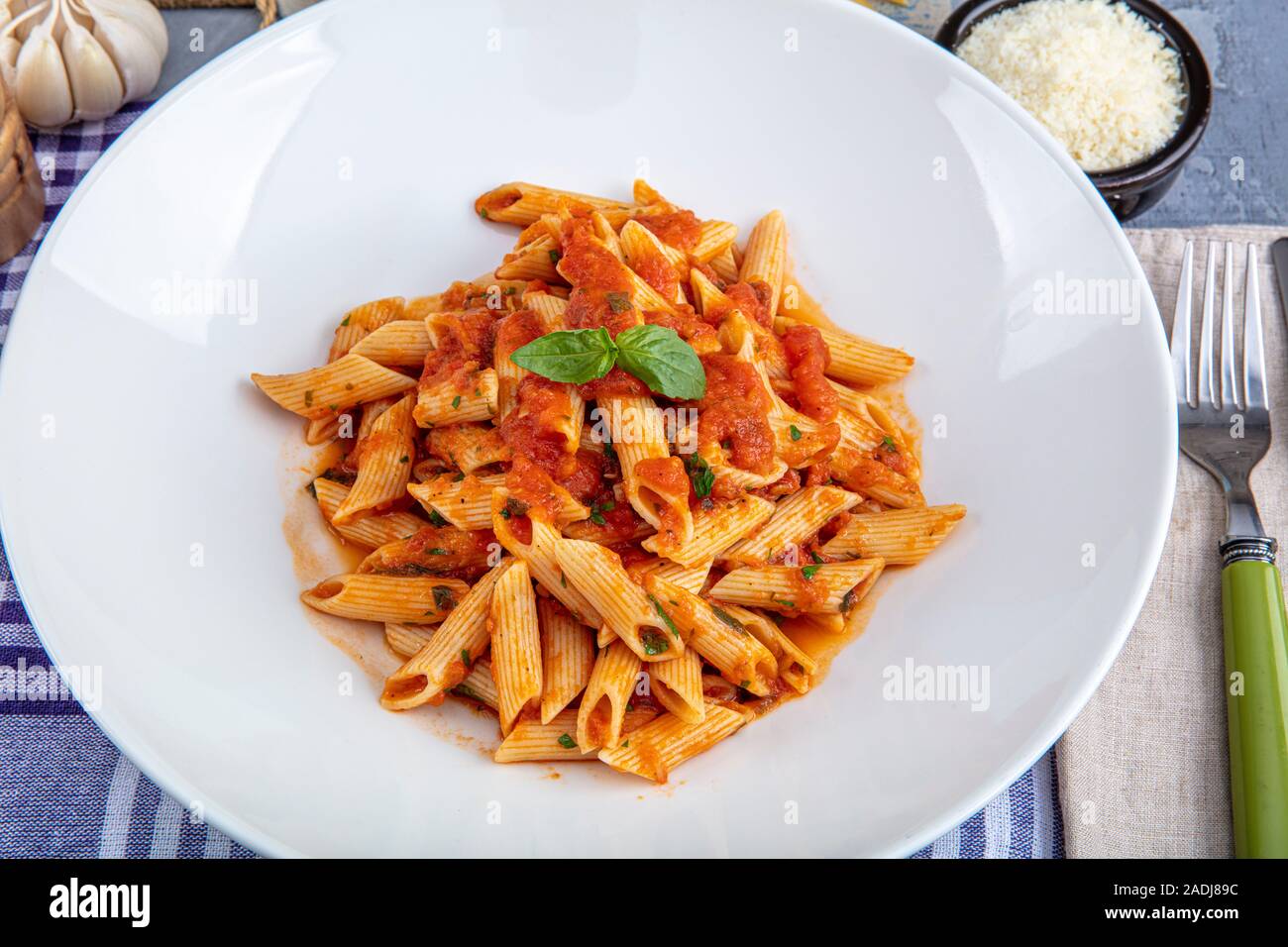 Pâtes penne avec sauce chili sauce arrabiata. L'arrabiata penne italienne  classique avec le basilic et le fromage pecorino fraîchement râpé sur une  table en bois rustique Photo Stock - Alamy