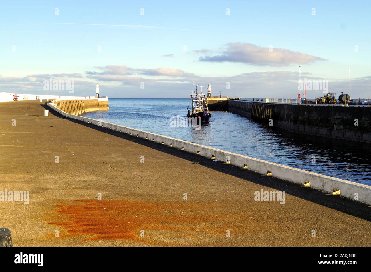 Bateau de pêche entre dans Coral Strand à marée haute le port de Ramsey, Ile de Man Banque D'Images