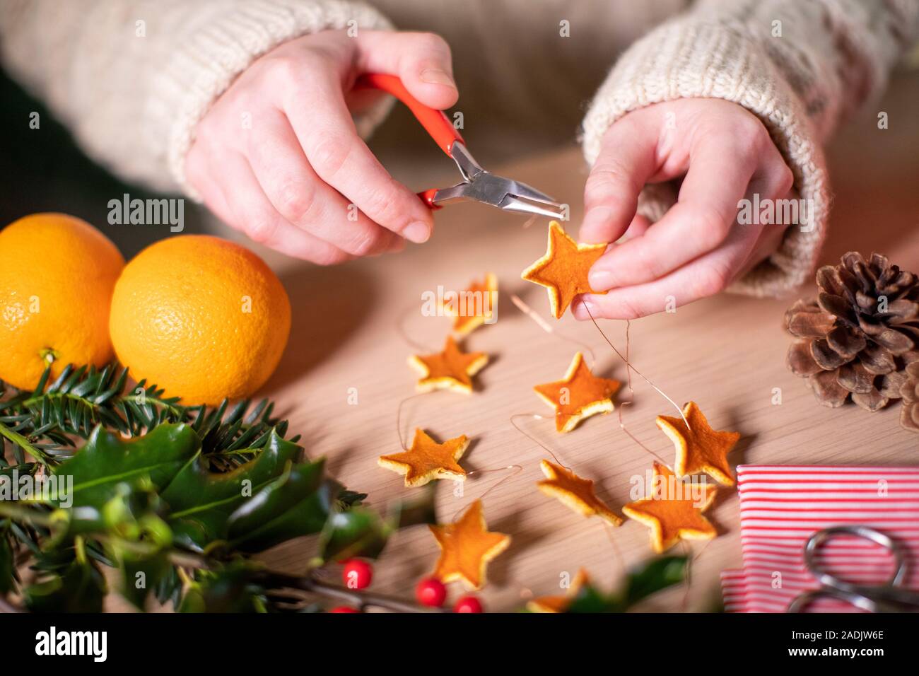 Close Up of Woman Making Eco Friendly Eco Décorations de Noël d'Orange Peel Banque D'Images