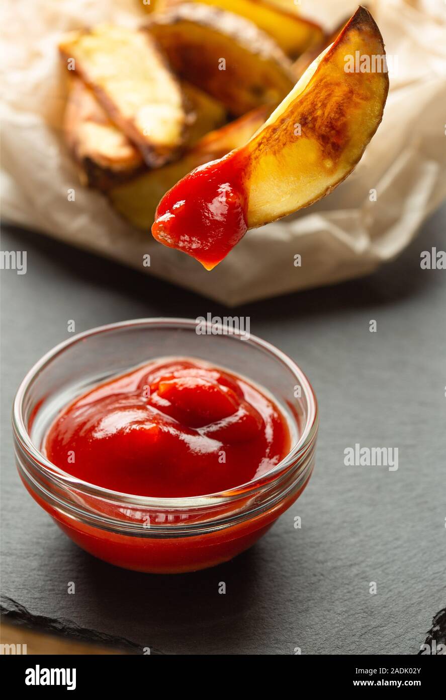 Tranche de pommes de terre frites et de la sauce tomate dans un bol en verre Banque D'Images