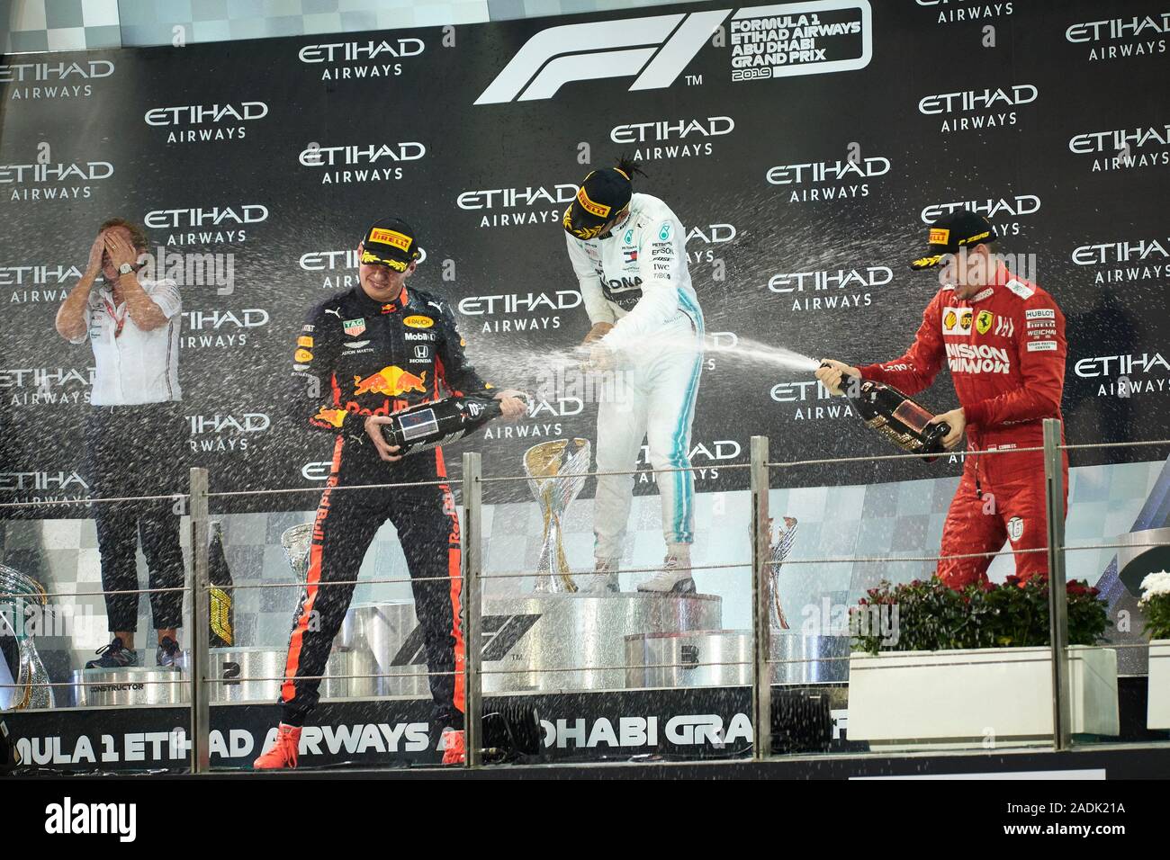 Gagnant Mercedes AMG Petronas F1 Team pilote britannique Lewis Hamilton (2e R), deuxième placé Red Bull Racing pilote néerlandais Max Verstappen (2L) et troisième placé la Scuderia Ferrari's pilote Monégasque Charles Leclerc (R) célèbrent après la Formule 1 Grand Prix d'Abu Dhabi course sur le Circuit de Yas Marina à Abu Dhabi. Banque D'Images