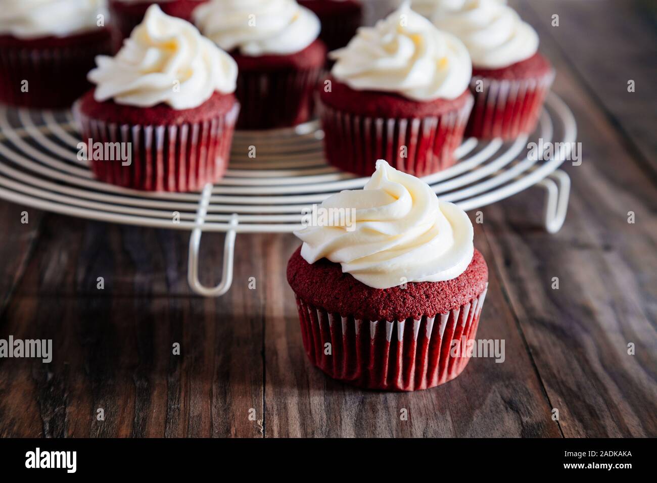 Red Velvet cupcakes sur une grille de refroidissement sur une table en bois rustique Banque D'Images