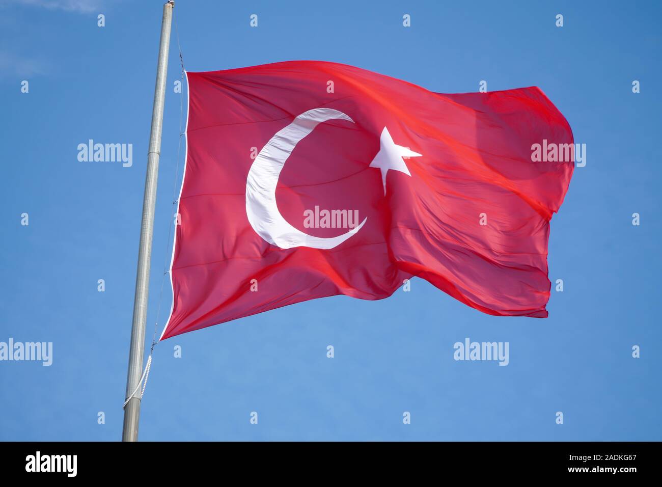 Brandir le drapeau turc sur ciel bleu Banque D'Images