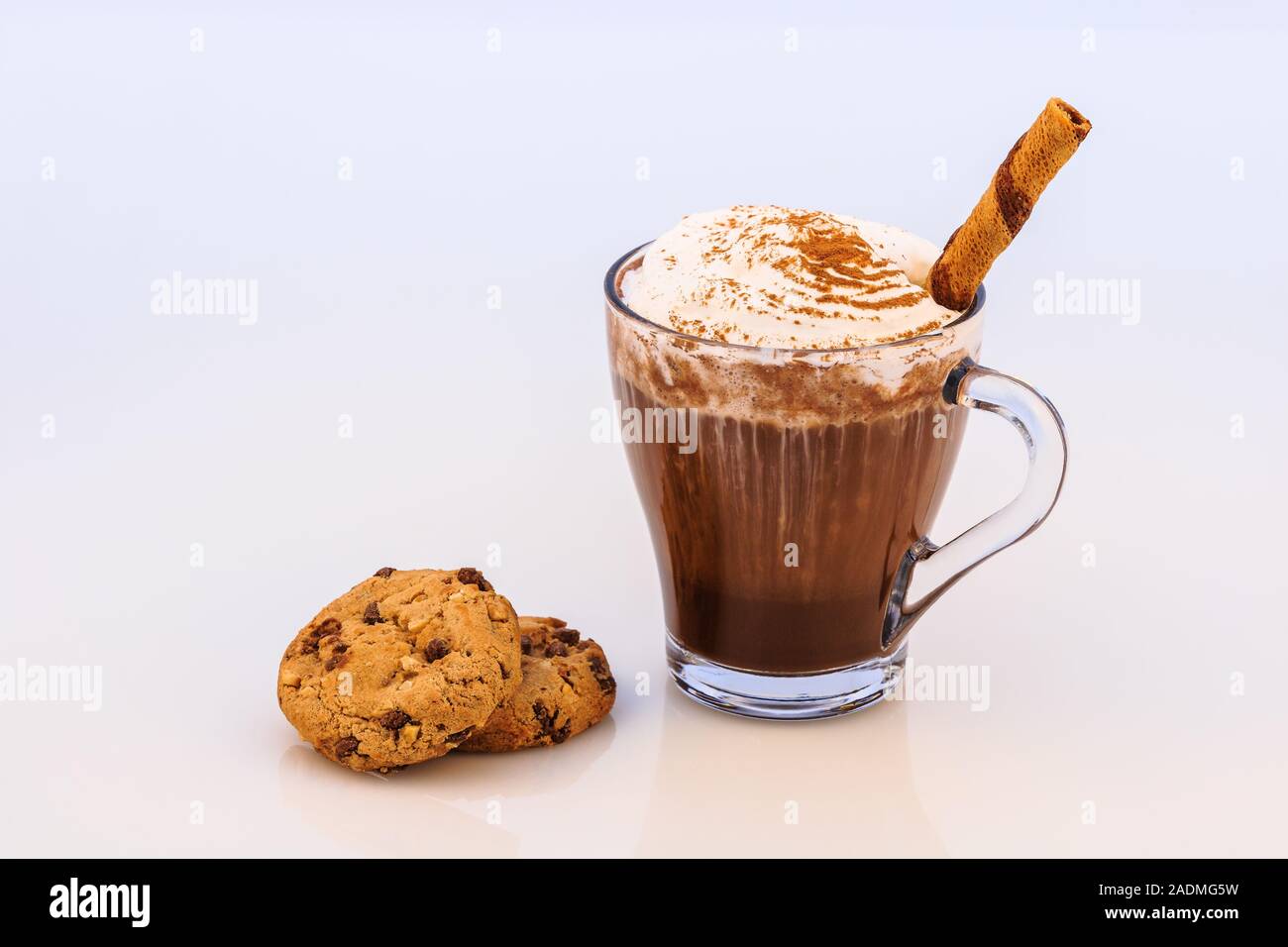 Chocolat chaud avec de la crème fouettée, la cannelle, l'anis, les biscuits  et les rouleaux de gaufrettes stick Photo Stock - Alamy
