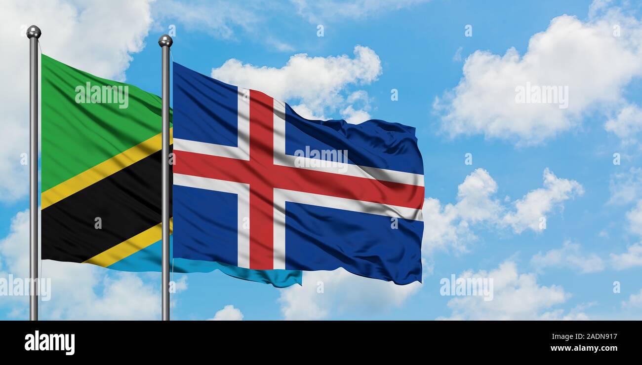 La Tanzanie et de brandir le drapeau de l'Islande dans le vent contre ciel bleu nuageux blanc ensemble. Concept de diplomatie, de relations internationales. Banque D'Images