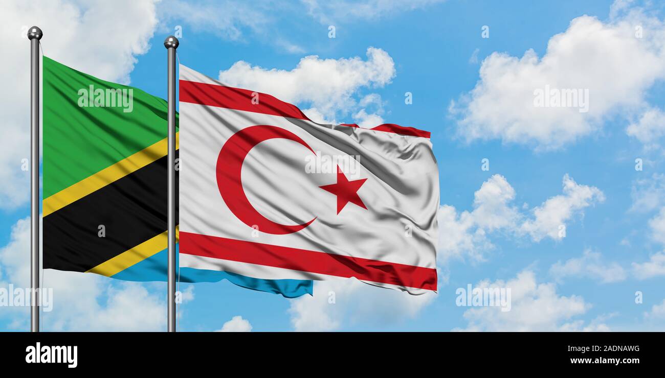 La Tanzanie et le nord de Chypre drapeaux dans le vent contre ciel bleu nuageux blanc ensemble. Concept de diplomatie, de relations internationales. Banque D'Images