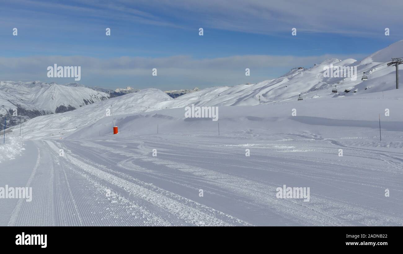La pente de descente à ski alpin avec de la neige fraîche, des pics de montagne dans l'arrière-plan, par une froide journée d'hiver Banque D'Images