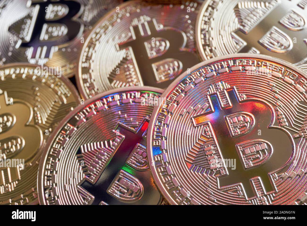 Beaucoup de monnaie blockchain crypto Bitcoin golden coins avec rose, orange, rouge, bleu et vert réflexions Banque D'Images