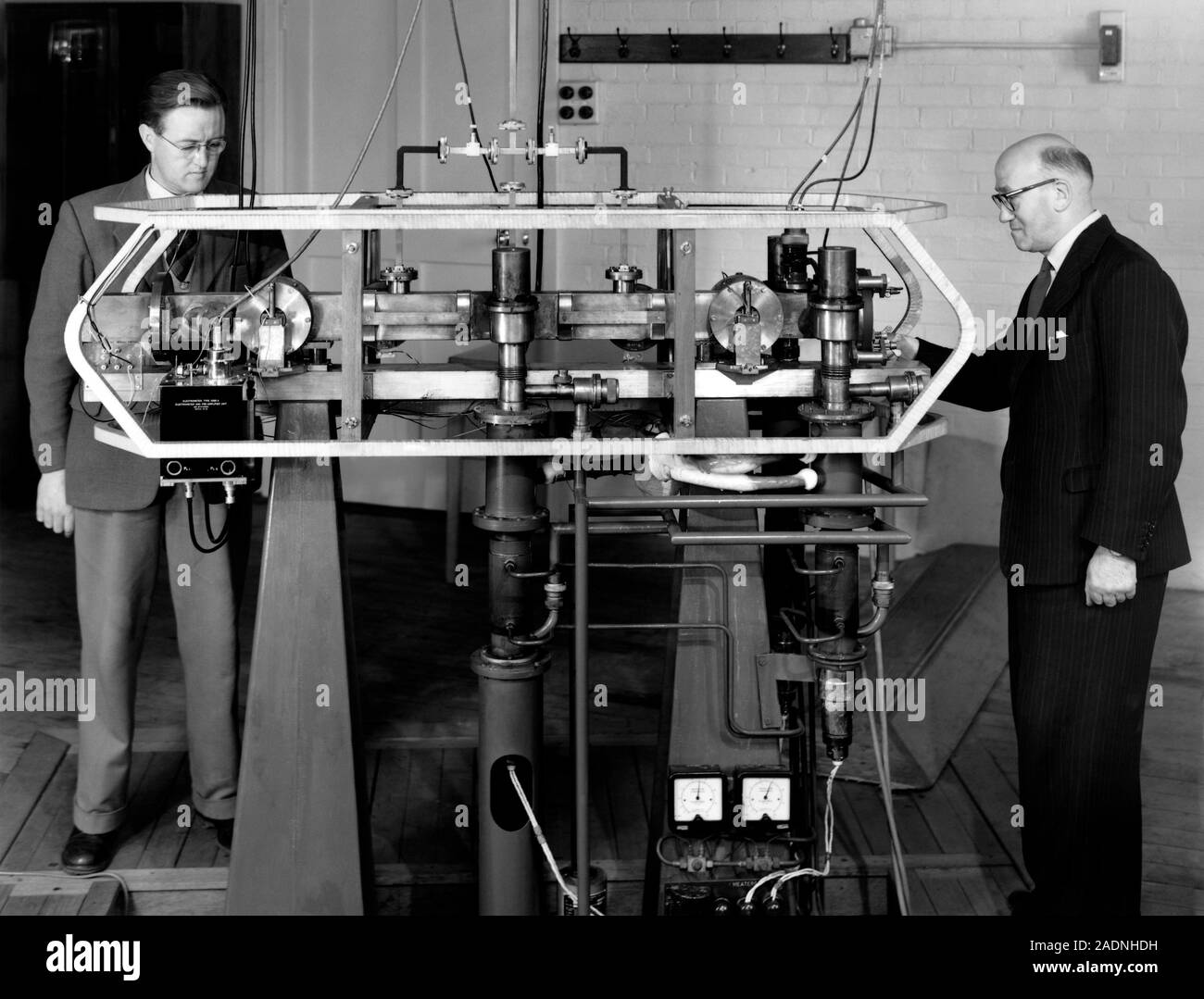 Horloge atomique au césium. Les physiciens Jack Parry (à gauche) et Louis  Essen (à droite) en ajustant leur résonateur de césium, qu'ils ont mis au  point en 1955. Les atomes d'v Photo